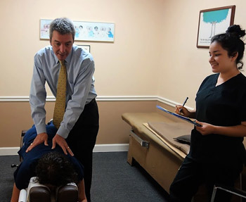 Dr. Gregg giving chiropractic adjustment.